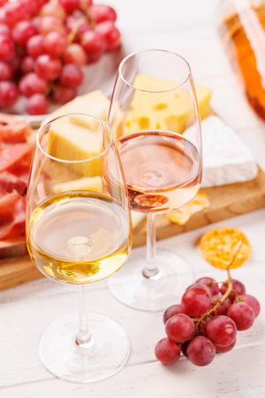 A delectable arrangement of various cheeses, fresh grapes, prosciutto and wine, creating an elegant display for a gourmet dining experience. Perfect for wine and cheese loversの写真素材