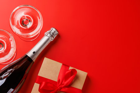 A glasses of champagne elegantly paired with a gift box, set against a romantic backdrop, creating the perfect Valentine's Day mood for celebration and loveの写真素材