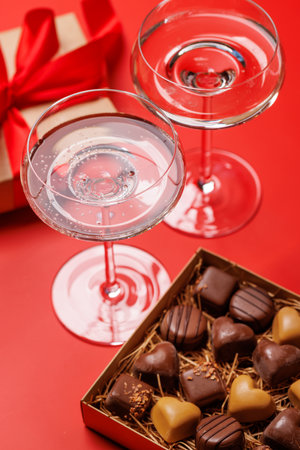 A glasses of champagne elegantly paired with a box of rich chocolates, set against a romantic backdrop, creating the perfect Valentine's Day mood for celebration and loveの写真素材