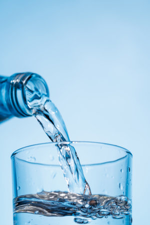 Crystal clear water being poured into a transparent glass, creating refreshing ripples and bubbles....