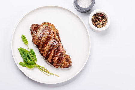 A perfectly cooked striploin steak with a juicy, tender texture on a white background. A gourmet meal for steak and wine loversの写真素材