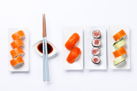 Assorted sushi and maki rolls beautifully arranged on plates, featuring fresh ingredients and vibrant colors, on a clean white backgroundの写真素材