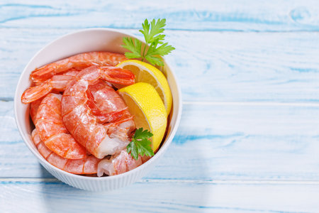Fresh shrimps, accompanied by sprigs of fresh parsley and juicy lemon. Ideal beer snack. With copy spaceの写真素材