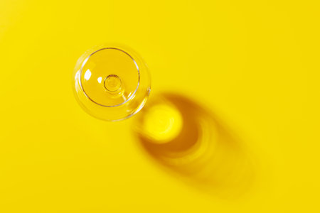 Wine glass on a bright background. The hard light creates sharp shadows, adding a dramatic effect to the scene, emphasizing the shapesの写真素材