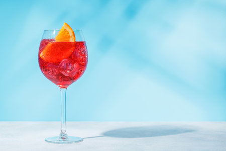 A cocktail arranged on a table against a light blue background, enhanced by sunny glares and playful shadowsの写真素材