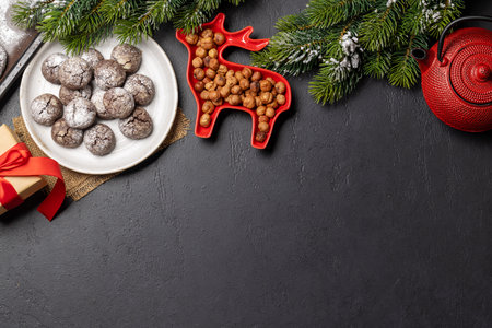 A festive assortment of Christmas cookies arranged on a plate, with Christmas decor and fir treeの写真素材