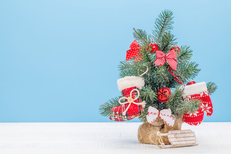 Cozy winter charm: Small decorated snowy Christmas tree with copy spaceの写真素材