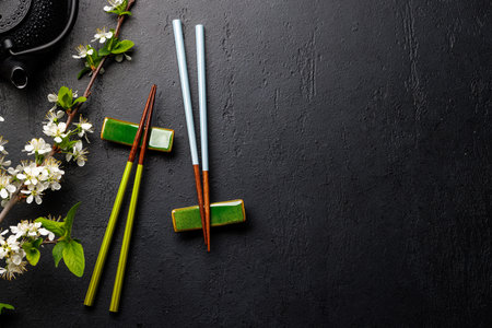 Table adorned with cherry blossom branch and chopsticks, epitomizing Japanese food culture, providing ample copy spaceの写真素材