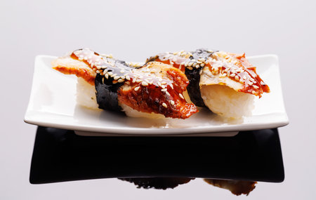 Sushi beautifully arranged on plate, featuring fresh ingredients and vibrant colors, on a clean backgroundの写真素材
