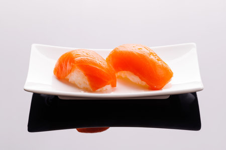 Sushi maki beautifully arranged on plate, featuring fresh ingredients and vibrant colors, on a clean backgroundの写真素材