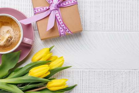 Easter gift box, coffee cup and yellow tulips. Flat lay with copy spaceの写真素材