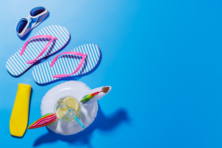 A vibrant summer vacation scene with flip flops, shades, and a floating flamingo with cocktail on a...