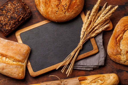 An assortment of freshly baked bread displayed on a table, showing different textures, shapes, and...