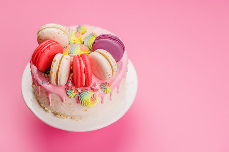 A beautifully decorated cake adorned with colorful macarons and vibrant decorations, creating a...
