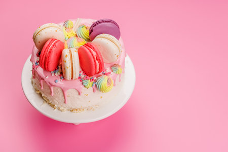 A beautifully decorated cake adorned with colorful macarons and vibrant decorations, creating a visually appealing and delicious dessert perfect for celebrations and special occasionsの写真素材