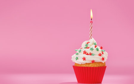 Festive cupcake topped with swirled frosting and a lit candle. Perfect for birthday celebrations or special occasions with copy spaceの写真素材