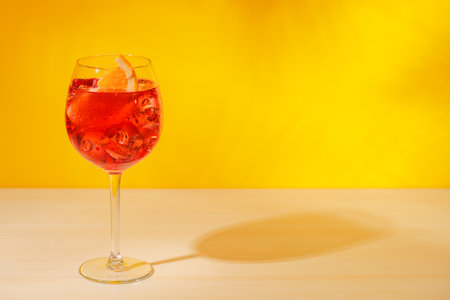 A cocktail arranged on a table against a light yellow background, enhanced by sunny glares and...