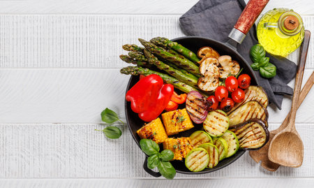 Assorted grilled vegetables on a frying pan, showcasing a colorful and healthy meal. Flat lay with copy spaceの写真素材