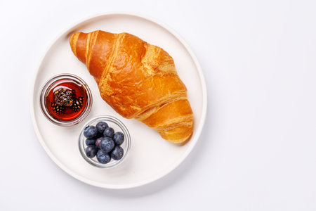 A freshly baked croissant served with ripe berries, sweet jam, creating a perfect breakfast or brunch momentの写真素材