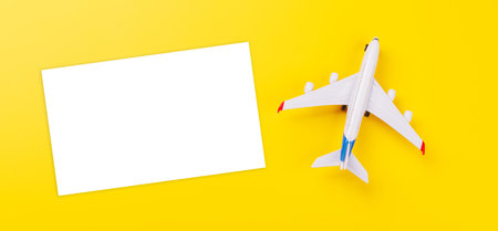 Travel-themed flat lay with blank photo card and toy airplane, arranged creatively on table with copy space for your ideasの写真素材
