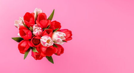 Pink and white tulip bouquet on a soft pink background, perfect romantic or springtime greeting conceptの写真素材