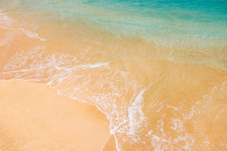 Sunny beach in Hawaii with golden sand, clear blue water under a bright skyの写真素材
