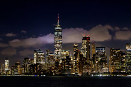 A vibrant sunset panorama of Manhattan downtown skyline, viewed from the river, with skyscrapers illuminated by warm, golden huesの写真素材