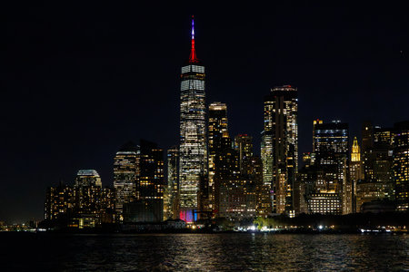 A vibrant sunset panorama of Manhattan downtown skyline, viewed from the river, with skyscrapers...