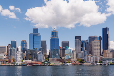 Bright and sunny panoramic view of Seattle skyline from the water, featuring the iconic Space Needle and city buildings under a clear blue skyの写真素材