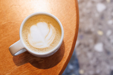 Warm cappuccino in a cup with latte art on top, symbolizing love and comfort in every sipの写真素材