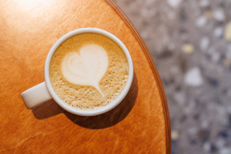 Warm cappuccino in a cup with heart-shaped latte art on top, symbolizing love and comfort in every sipの写真素材