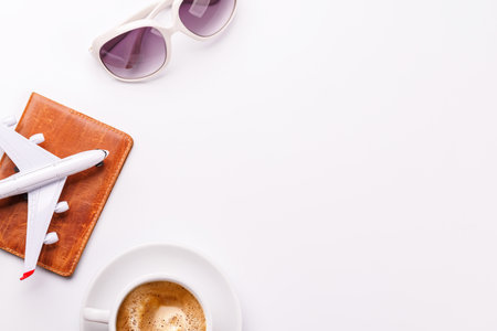 Travel-themed flat lay with camera, toy airplane, and coffee, arranged creatively on table with copy space for your ideasの写真素材