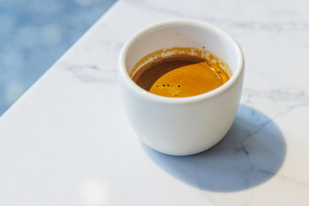 Freshly brewed espresso served in a small cup on a table, capturing the rich aroma and bold flavor of a perfect coffee momentの写真素材
