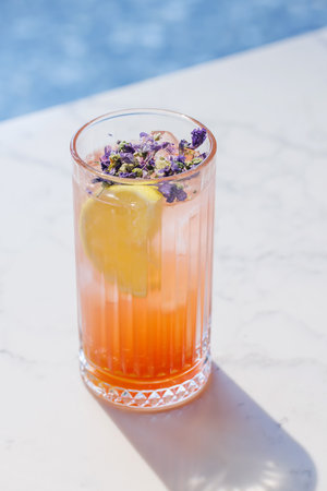 Refreshing summer lemonade with orange and lemon slices, served cold in a glass with iceの写真素材