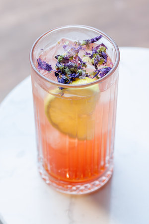 Refreshing summer lemonade with orange and lemon slices, served cold in a glass with iceの写真素材
