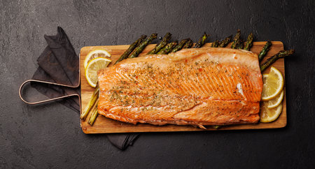 Grilled salmon fillets and asparagus on wooden board