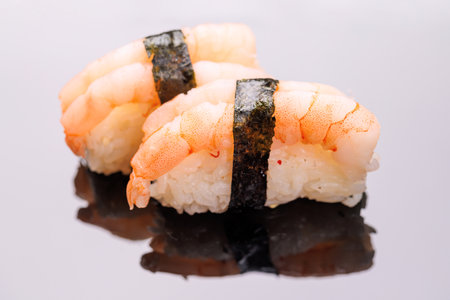 Sushi beautifully arranged, featuring fresh ingredients and vibrant colors, on a clean black backgroundの写真素材