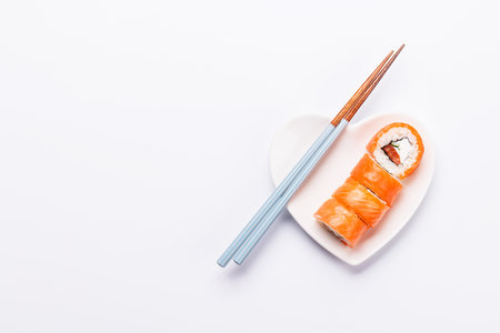 A heart-shaped plate filled with delicious sushi, accompanied by chopsticks, symbolizing love for Japanese cuisineの写真素材