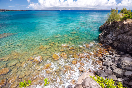 Beautiful Maui landscape in Hawaii featuring a sandy beach, turquoise sea, and lush greenery