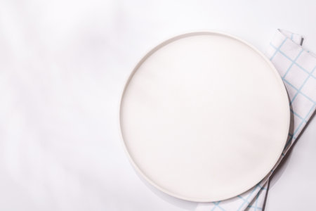 Empty plate on white background, food mockup with natural light. Flat layの写真素材