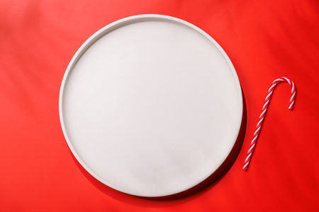 Empty plate on red background, Christmas food mockup.の写真素材