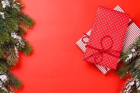 Christmas background with snowy fir tree branches on red surface and copy spaceの写真素材