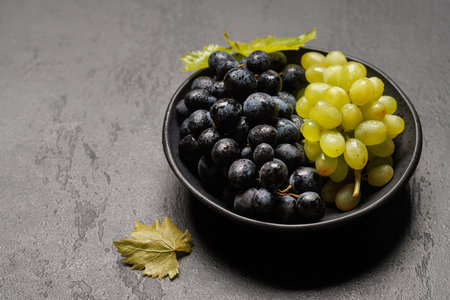 Fresh grapes bowl on a stone table with copy spaceの写真素材
