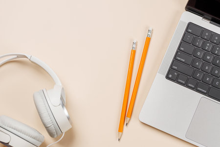 Laptop and stationery on beige workspace, top view with copy space, minimal office backgroundの写真素材