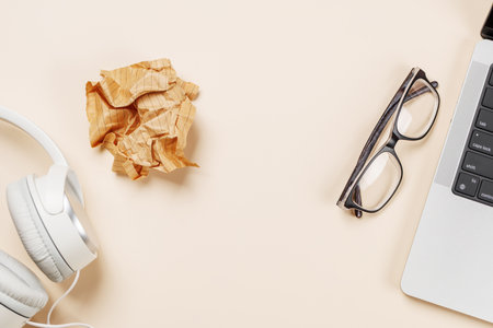 Laptop and stationery on beige workspace, top view with copy space, minimal office backgroundの写真素材