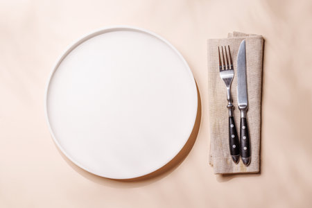 Empty plate on beige background, food mockup with natural light. Flat layの写真素材