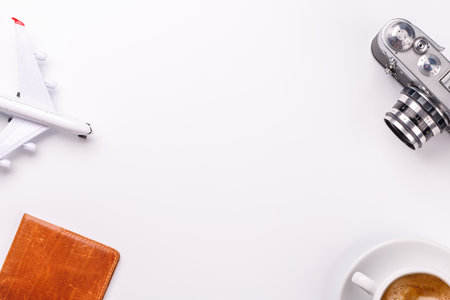 Travel-themed flat lay with camera, toy airplane, and coffee, arranged creatively on table with copy space for your ideasの写真素材