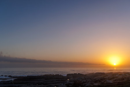 Colorful sunset over the Atlantic Ocean with warm light, calm waves and scenic evening atmosphereの写真素材