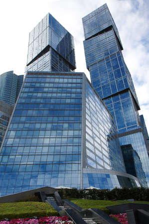 lawn on which there is high-rise glass building with sky reflections