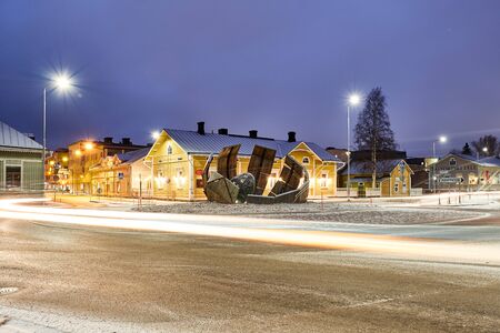 Joensuu, Finland - November 23, 2018: The new roundabout at night with light trails. In the center of the intersection is a modern art object. Old European city.のeditorial素材